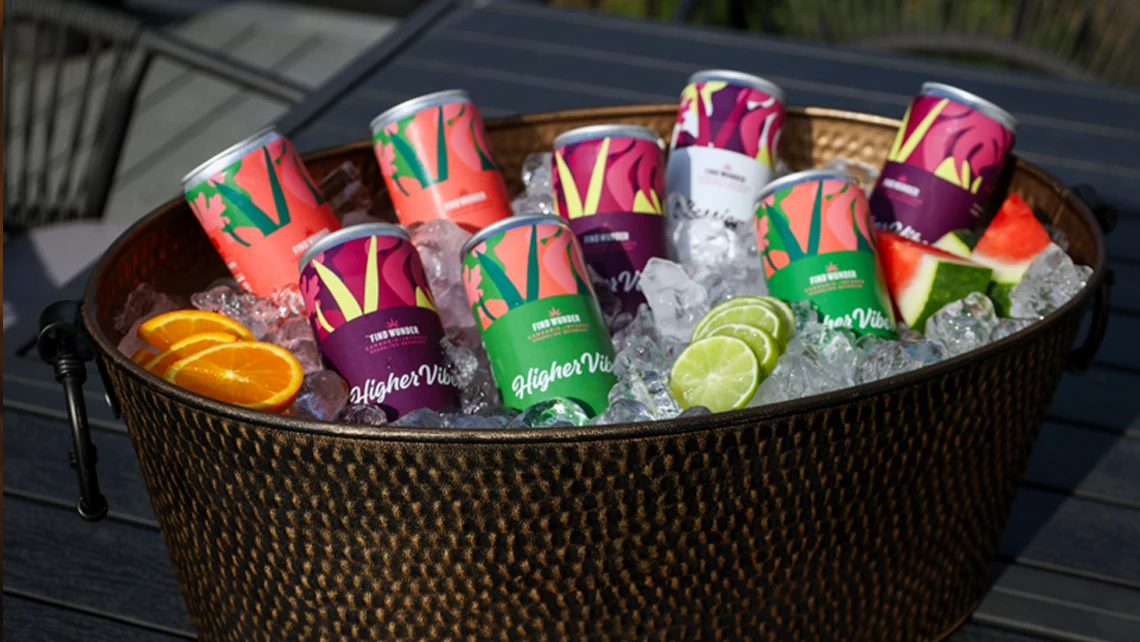 Wunder THC beverages and slices of orange, watermelon, and lime inside basket filled with ice cubes.