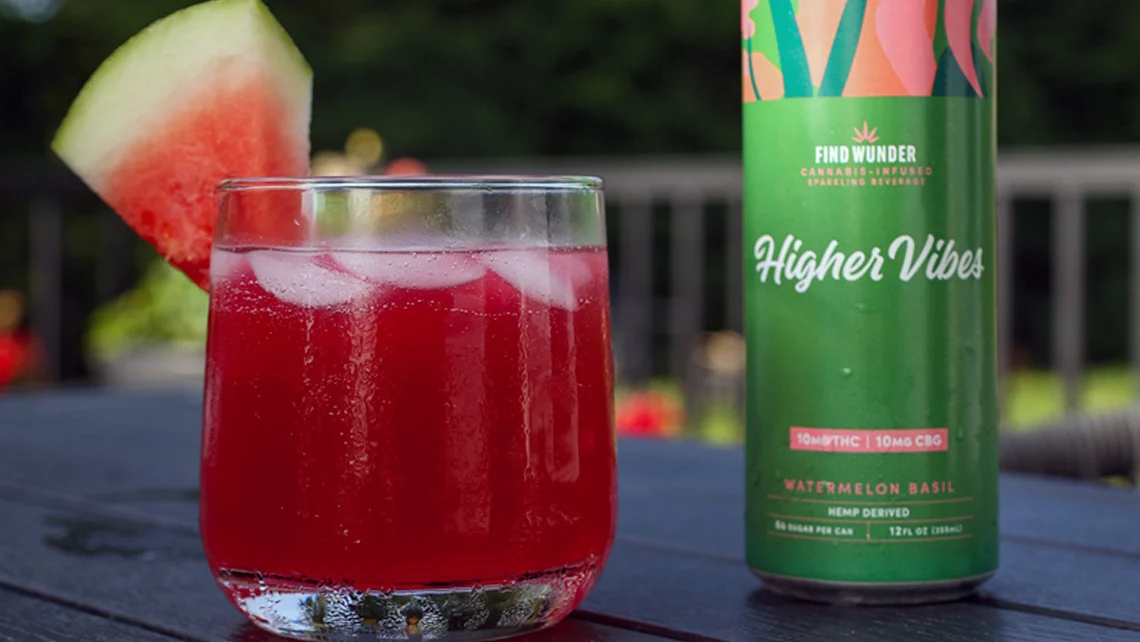 A Wunder Watermelon Basil can beside a glass of watermelon basil drink with a watermelon wedge